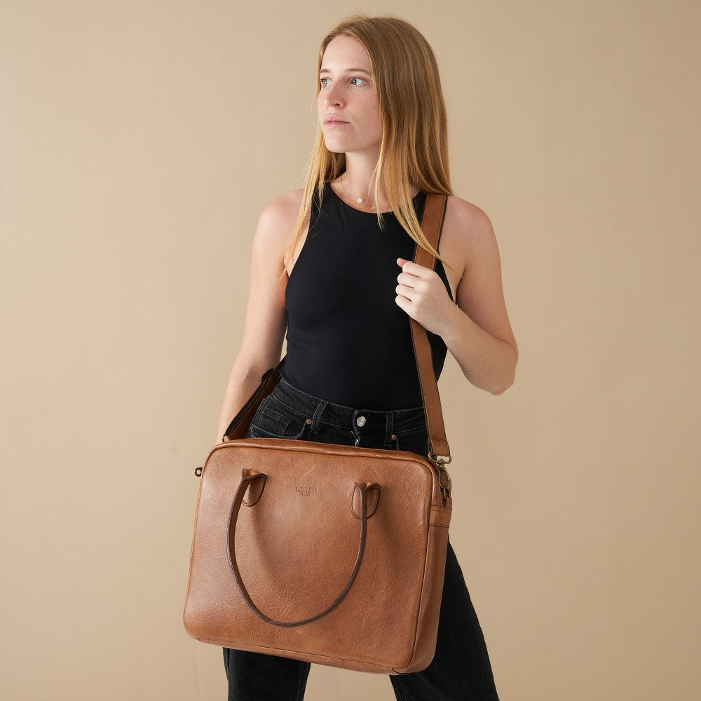 Model posing with 15" Genuine Leather Laptop Bag - Pecan | Woodstock Leather