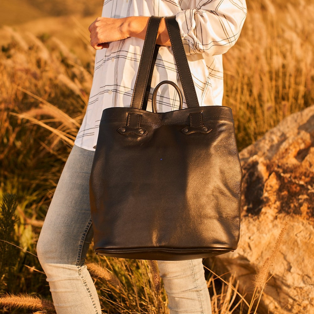 Woman holding Haley Backpack-Black by straps on her arm