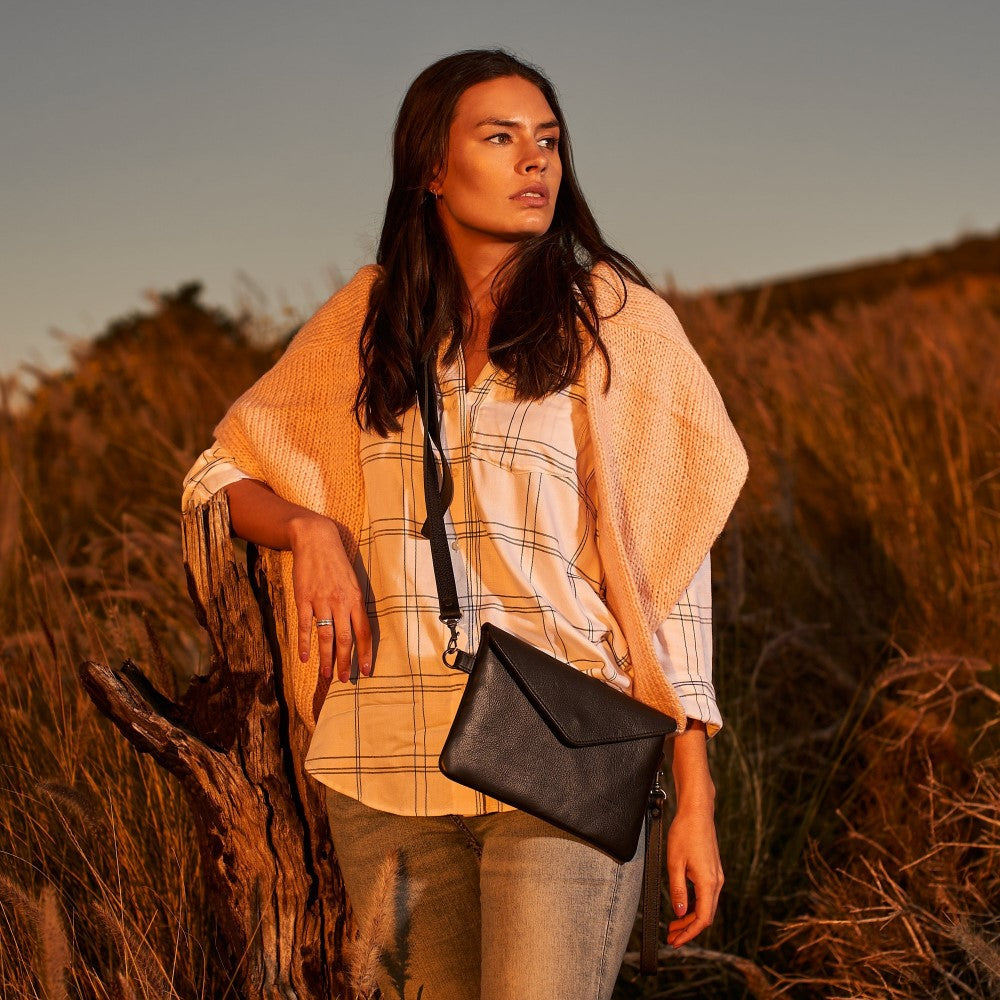 Woman with Marley Clutch Bag - Black worn as a crossbody bag