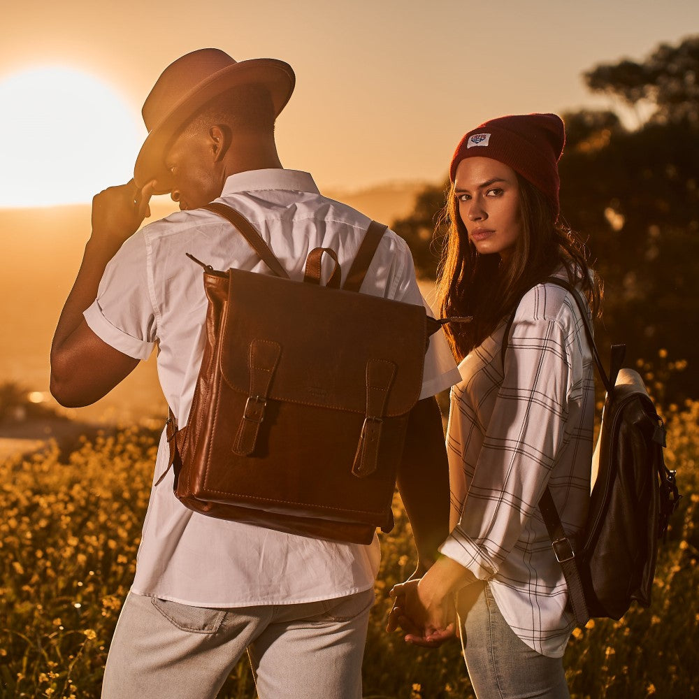 Man and woman wearing Black and Pecan Peyton 15" Laptop Backpack on their backs
