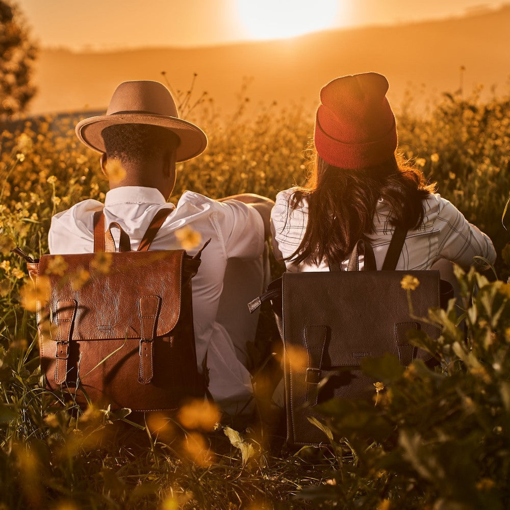 Man and woman outdoors wearing Peyton 15" Laptop Backpack in Black and Pecan