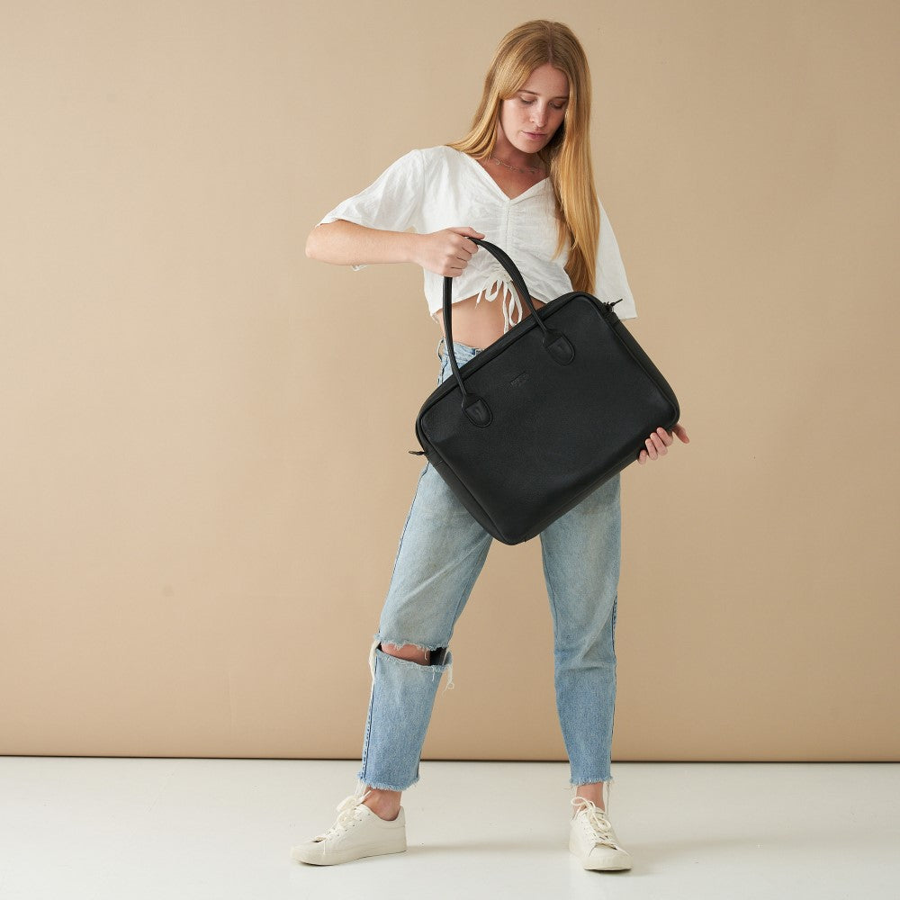 Model posing with 15&quot; Genuine Leather Laptop Bag - Black | Woodstock Leather 