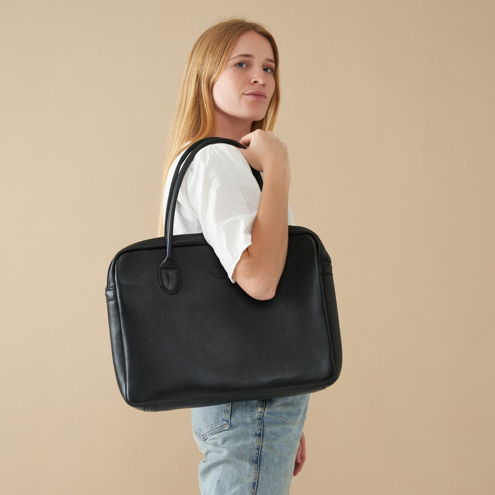 Model posing with 15&quot; Genuine Leather Laptop Bag - Black | Woodstock Leather