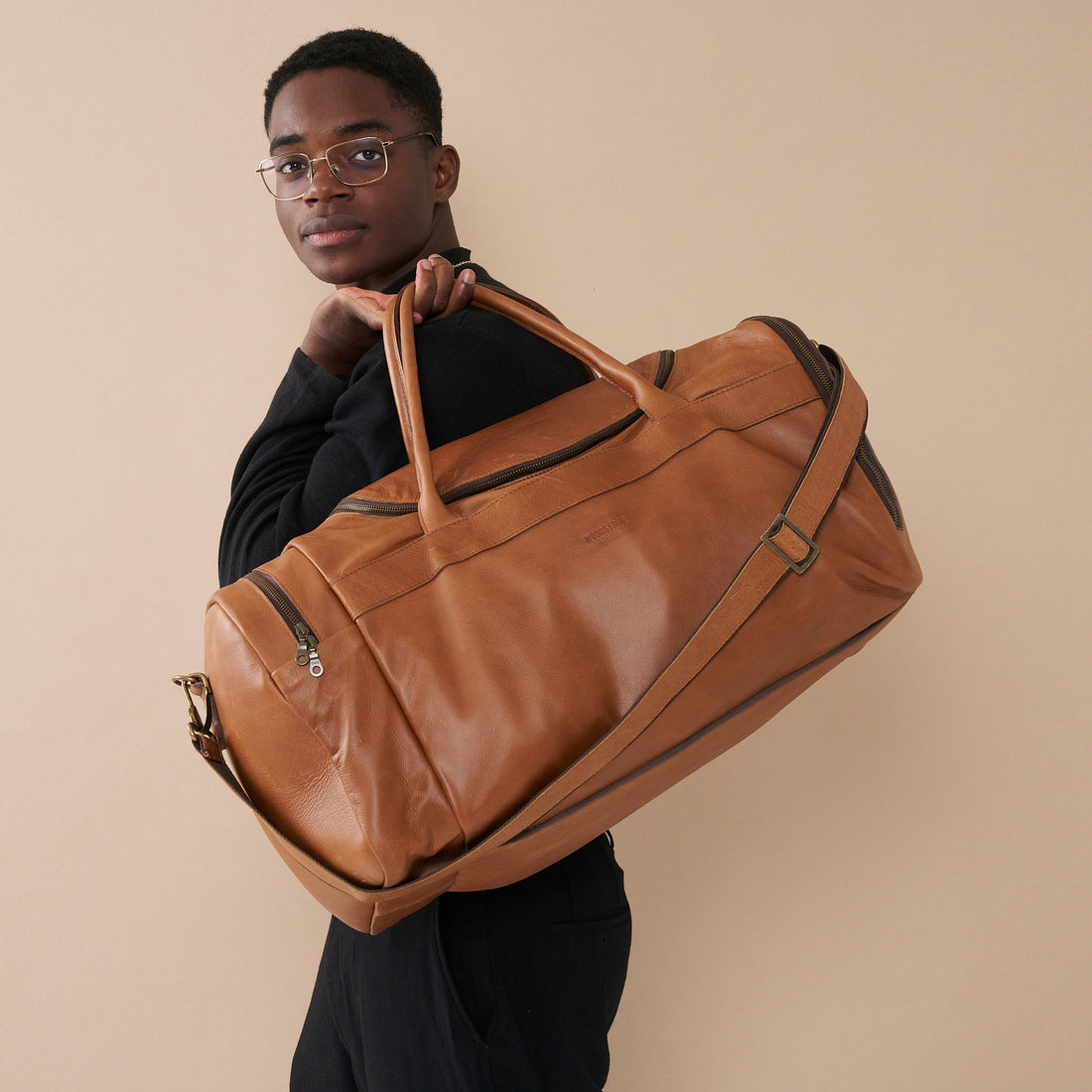 Model with Pecan Genuine Leather Sports Duffel Bag with Waterproof Lining &amp; Sneaker Compartment over his shoulder