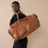 Model with Pecan Genuine Leather Sports Duffel Bag with Waterproof Lining & Sneaker Compartment over his shoulder