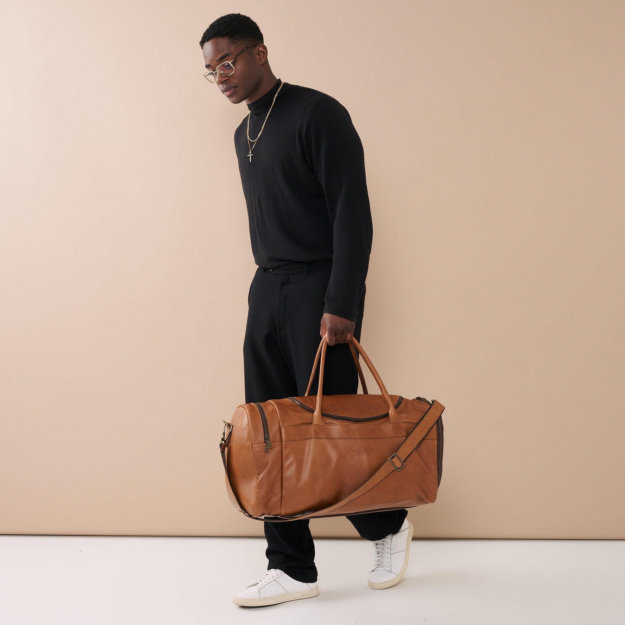 Model holding Pecan Genuine Leather Sports Duffel Bag with Waterproof Lining &amp; Sneaker Compartment